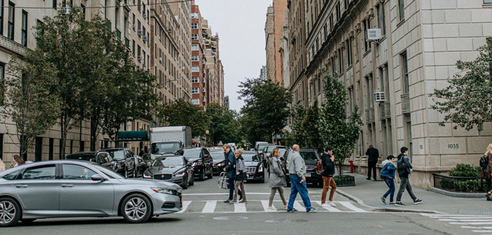 the middle of a New York street with pedestrians and cars