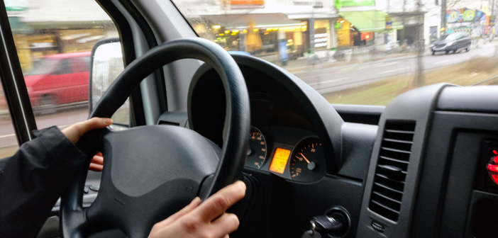 close up of hands on a car's steering wheel